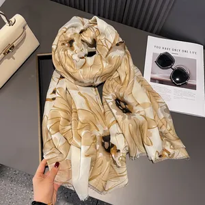 Close-up of daisy pattern linen scarf with natural fringed edges on a desk
