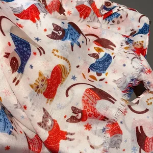 Detail view of cat paradise print scarf with colorful sweaters and soft frayed edges