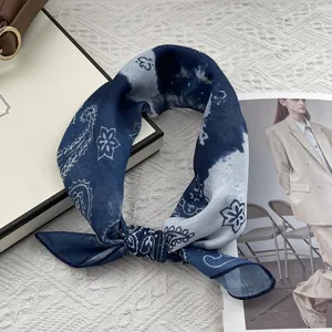 Navy blue paisley cotton linen square scarf styled on a white textured background