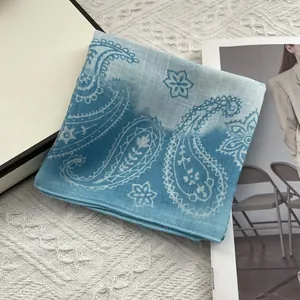 Detail of blue paisley cotton linen scarf showing delicate machine-stitched edges
