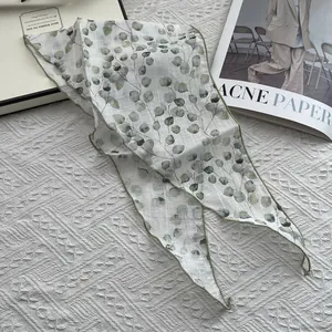 Lightweight linen triangular scarf with green leaf print on a soft knit background