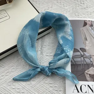 Detailed view of tied blue paisley cotton linen scarf with elegant floral patterns