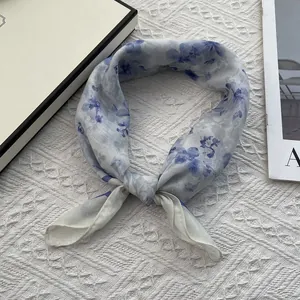 Detailed macro view of a light floral cotton linen neck scarf with blue flower pattern