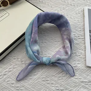 Detailed view of lightweight blue floral cotton linen square scarf tied in a soft knot