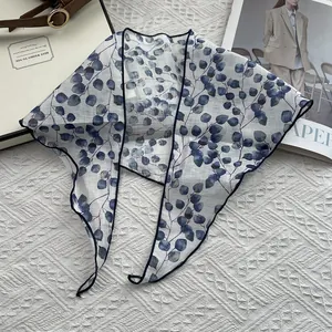 Flat lay of breathable linen scarf with blue leaf patterns and fine edge detail
