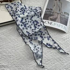 Detail of pure linen scarf with eucalyptus leaf pattern and fine dark blue hemmed edges