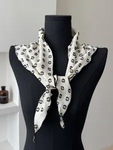 Detailed view of white cotton-linen scarf featuring black polka dot embroidery on a model