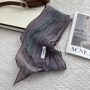 Detail of multi-color striped linen scarf with fabric label showing premium material
