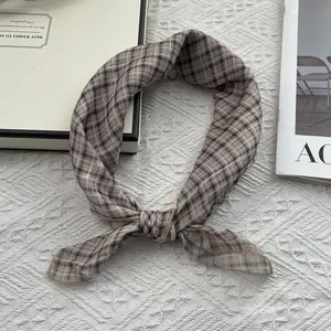 Dettaglio di un foulard a scacchi marrone caffè in chiffon leggero con cuciture fini