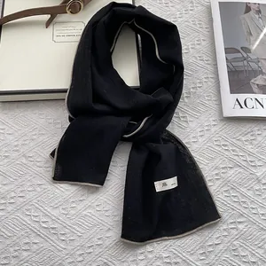 Detail of black linen scarf featuring contrast stitching and minimalist fabric texture