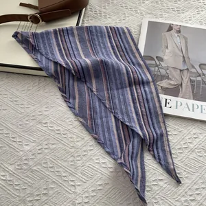 Detail view of cotton neckerchief featuring colorful vertical stripes on a textured background