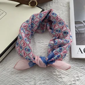 Detail eines rosa-blau karierten Seidentuchs mit Comicfiguren, als Knoten gebunden