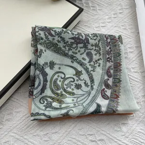 Detail of soft cotton linen paisley scarf featuring light green and purple patterns