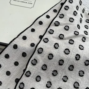 Macro detail of polka dot jacquard fabric showing textured cut-pile cotton linen weave
