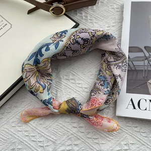 Detailed view of floral cotton linen neck scarf on white knit background with accessories