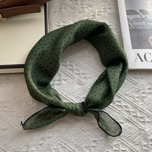 Detail of forest green polka dot cotton scarf with premium hemmed edges and silky texture