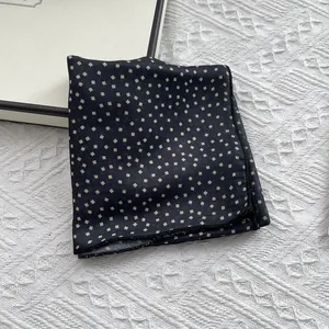 Detail of forest green square scarf with small beige geometric prints and silky luster