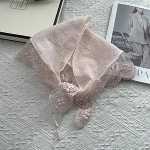 Close-up of light pink scarf with exquisite lace edges and 3D floral embroidery detail