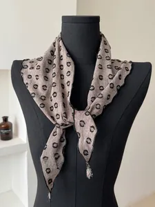 Detail of light grey cotton linen scarf featuring black polka dots and fine edge stitching