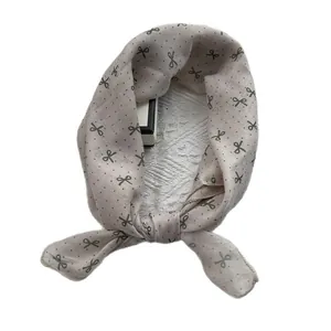 Light gray cotton linen scarf with black scissors and polka dot print tied in a soft knot