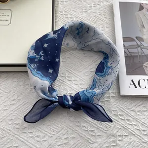 Close-up of nautical map print silk square scarf styled as a hair tie on white fabric
