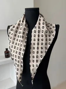 Detail view of beige polka dot cotton linen scarf showing texture on a mannequin