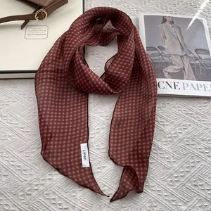 Detail of thin red-brown checkered linen scarf paired with a brown leather handbag