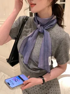 Detail showing elegant purple striped linen scarf tied as a stylish necktie on model