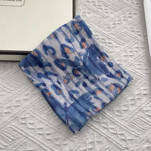 Detailed view of blue and orange leopard print square scarf in cotton linen blend texture