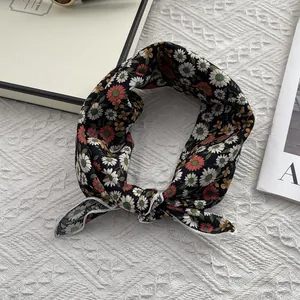 Détail d'un foulard en coton à imprimé marguerites avec bords cousus blancs