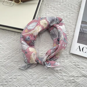 Detailed shot of pink cotton scarf with white seashell patterns and clean hem stitching