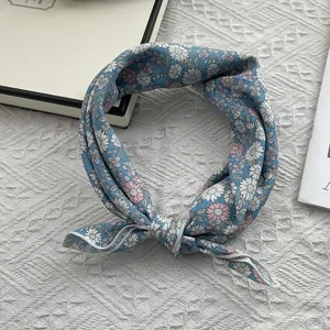 Détail d'un bandana en coton bleu avec imprimé marguerites et texture douce et souple