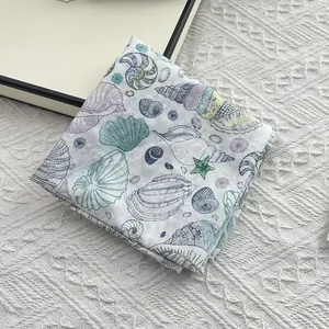 Detail of cotton square scarf featuring hand-drawn seashell and conch ocean prints