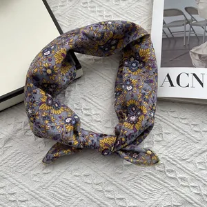 Detailed view of a vintage floral headscarf in blue-grey fabric with yellow patterns