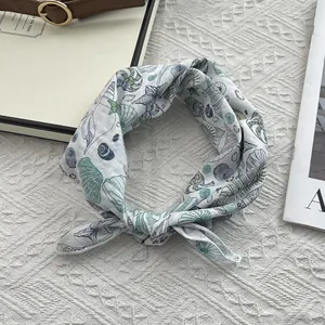 Detail of white cotton square scarf with blue ocean patterns like shells and starfish