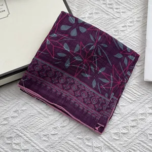 Detail of floral linen neckerchief showing pink stitched edges and geometric floral patterns