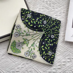 Close-up of floral cotton scarf with green vine and daisy print on textured background