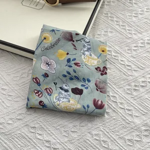 Close-up of a cotton square scarf featuring vintage rabbit and floral patterns in sage green