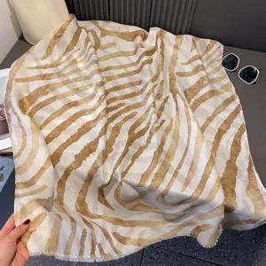 Detail of zebra pattern scarf with fringe edges, light beige and dark brown woven texture