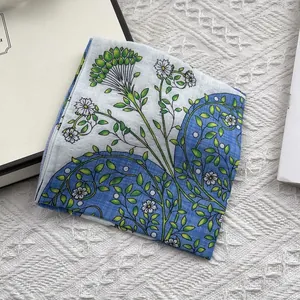 Detail of floral cotton linen scarf with blue daisy print on soft textured fabric