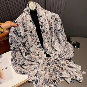 Detail of floral lightweight shawl with elegant blue tassels and artistic pattern