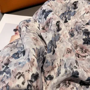 Detailed macro view of floral print silk scarf textures with artistic ink painting patterns