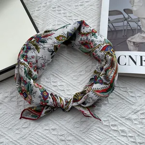 Close-up of floral cotton square scarf with ethnic paisley print and red stitched edges