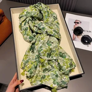 Yellow and green floral cotton scarf displayed with fashion magazine and accessories