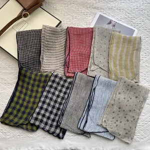 Detailed flat lay of ten patterned linen scarves with classic checks, stripes and dots