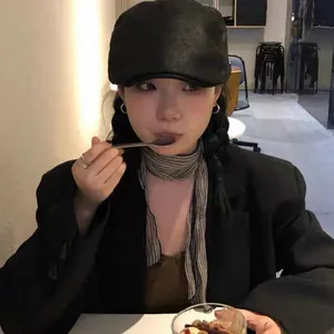 Classic black faux leather newsboy cap styled with a striped scarf for casual chic outfit