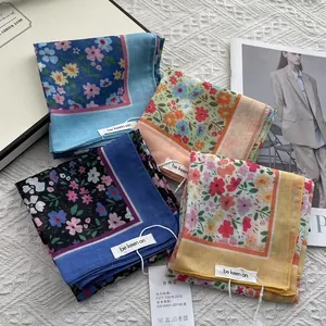Floral print scarves in pastel colors with rolled edges on a stylish background