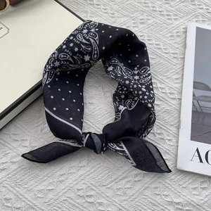 Macro detail of breathable cotton-linen scarf with black and white paisley and dot patterns