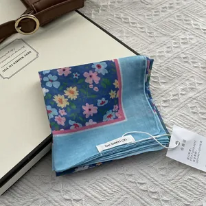 Folded light blue floral square scarf with a fresh forest-style pattern for women