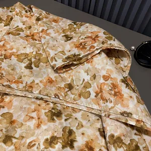 Detail of yellow-green floral cotton-linen scarf with fine rolled edges and retro pattern